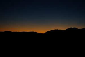 jagged horizon barely lit against an faded setting sun