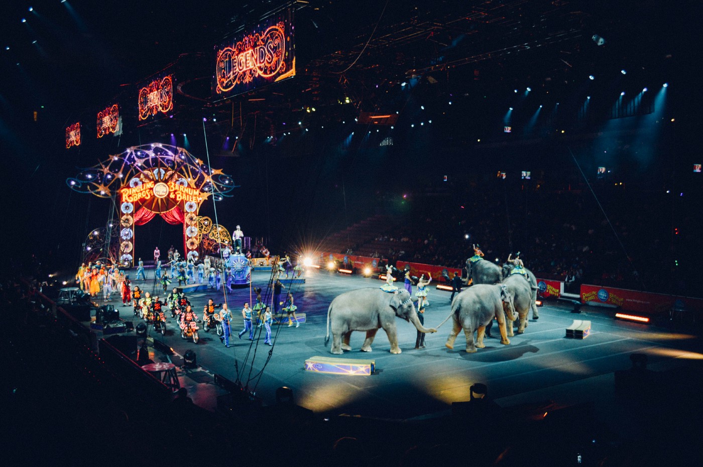 three ring circus filled with performers and elephants