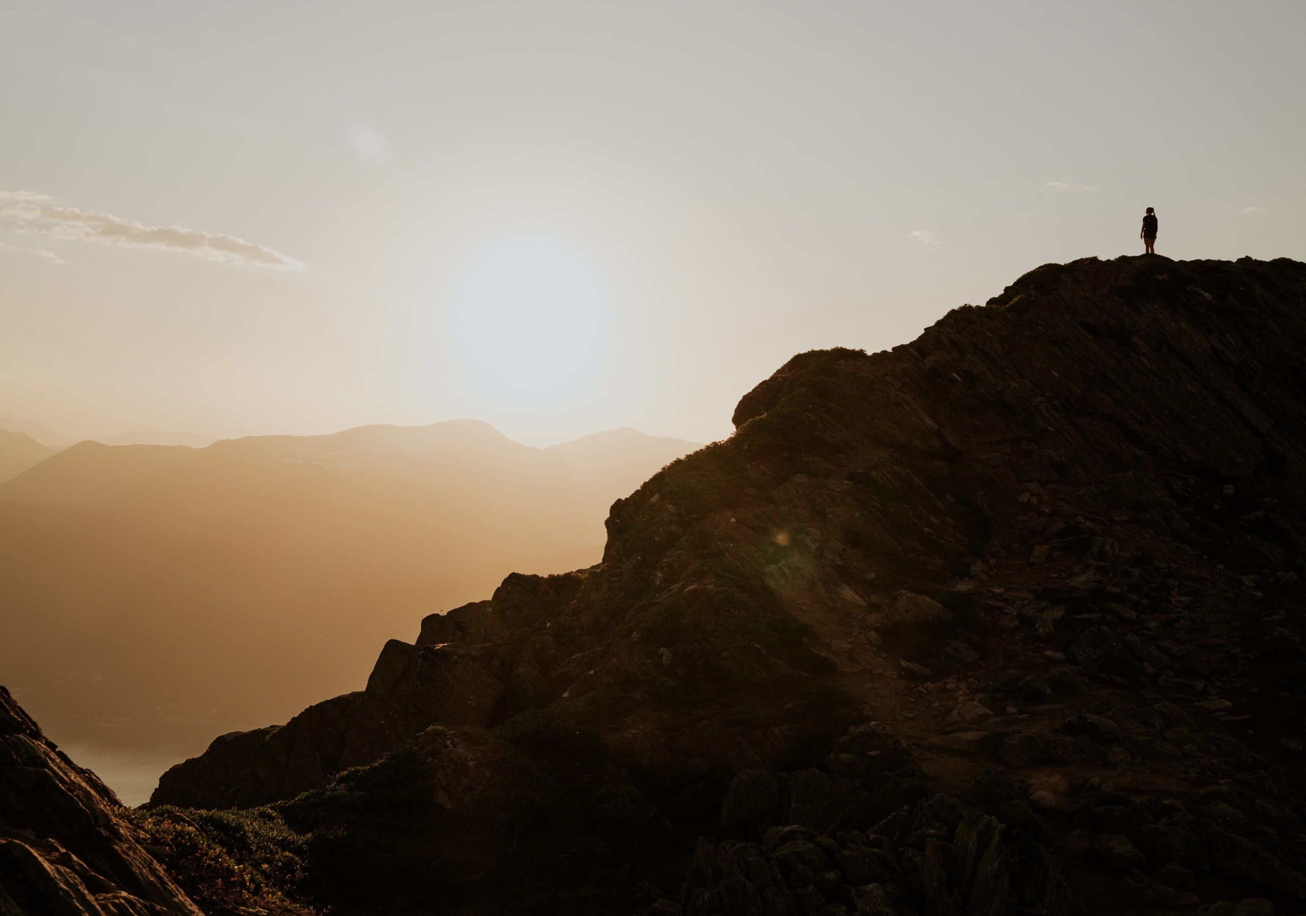 a small person on a distant mountain ridge against the rising sun - tag common creator mistakes to avoid