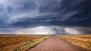 long dirt road fading into a distant stormy sky on totally flat open empty plain - a compelling experience for sure